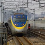 pexels-photo-13862115-13862115 A sleek train approaches a station in a bustling Taiwanese city, showcasing modern rail technology.